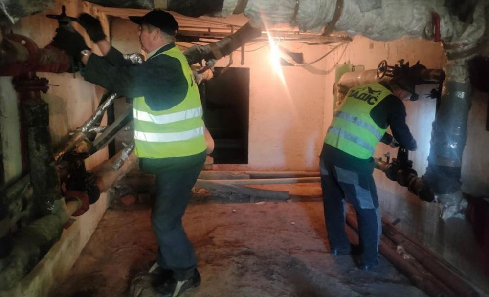 слюсарі перевіряють труби у підвалі будинку