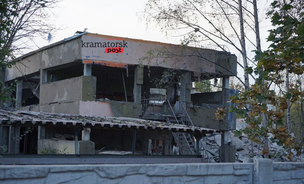Будівля дитсадка у Краматорську з вибитими вікнами, пошкодженим фасадом та розкиданими будівельними матеріалами навколо. Зліва видно дитячий майданчик