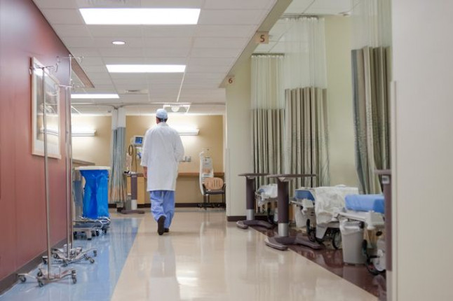 doctor-walks-down-hospital-corridor